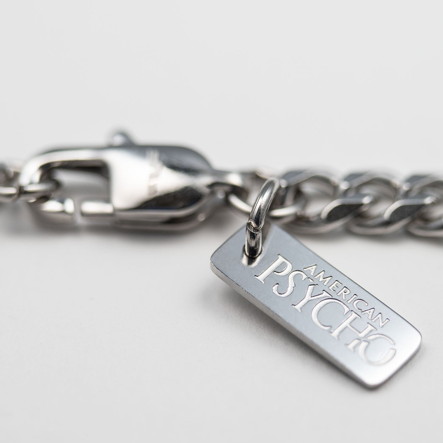 Detailed view of the Personal Fears X American Psycho Nail Gun Necklace tag