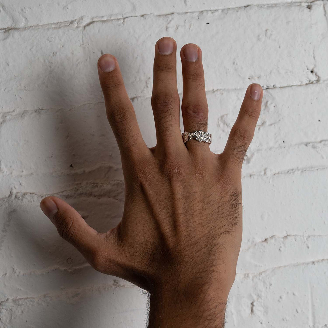 Silver flower and star ring on male hand